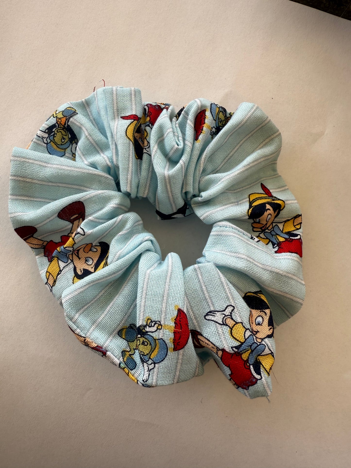 Scrunchie with cartoon character design on a beige background