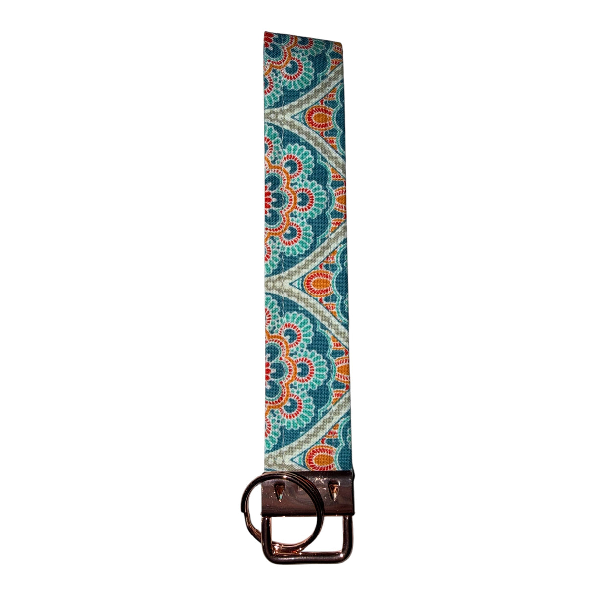 A long fabric belt with a detailed teal, orange, and white paisley pattern, finished with a dark brown leather end and a dark metal ring buckle.